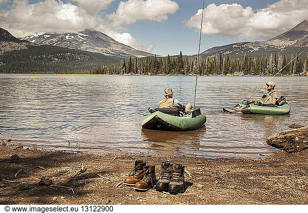 Men rafting on lake against mountains