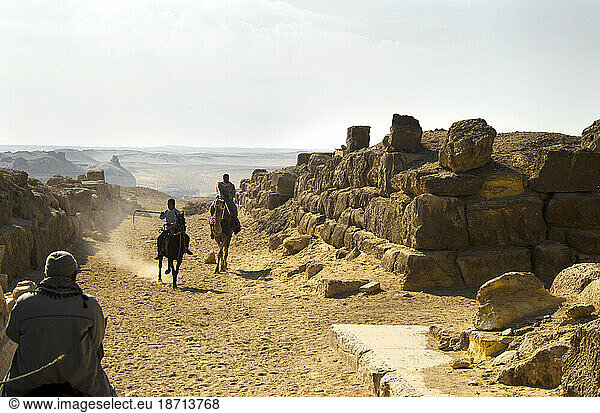 Men ride through a slim desert passage in Cairo Egypt