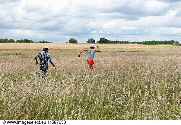Men running in wheat field