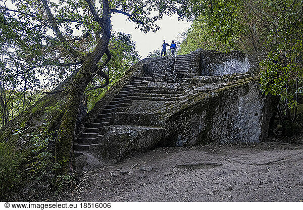 Men standing over Etruscan Pyramid of Bomarzo