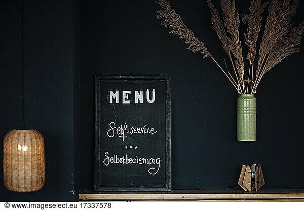 Menü-Tafel vor schwarzer Wand im Café
