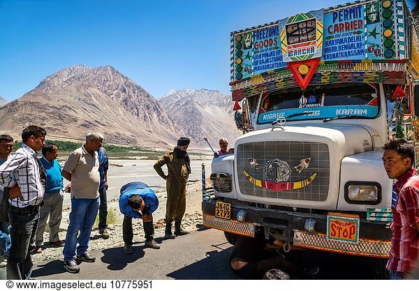 Men watching a flat tyre in the Nubra-Leh road across Khardung La  the highest motorable pass in the world.