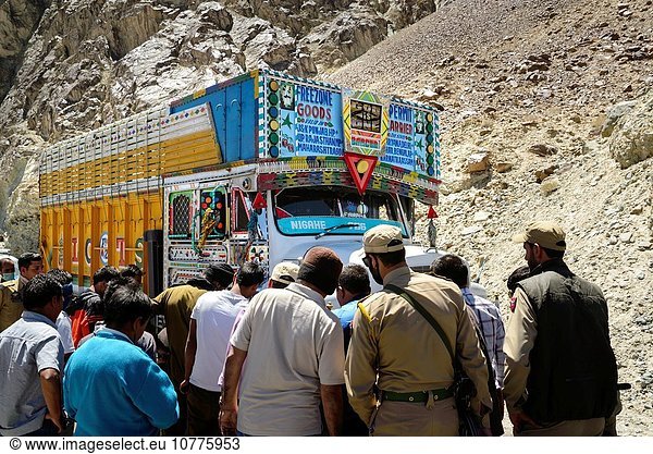 Men watching  some helping  during the fixing of a flat tyre in Nubra valley's main road to Khardung La.