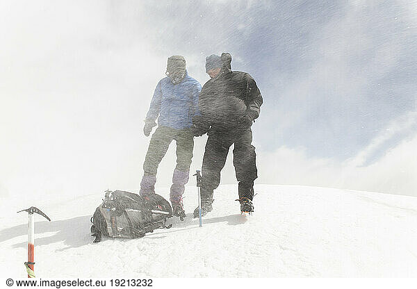 Men with backpack hiking on mountain in snow