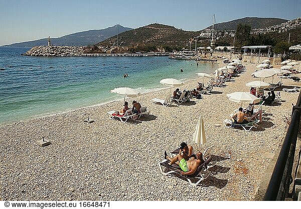 Menschen beim Sonnenbaden am öffentlichen Strand  Kalkan  Provinz Antalya  Mittelmeerküste  Region Altes Lykien  Türkische Riviera  Türkei  Europa.