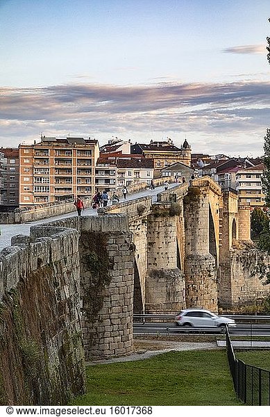 Menschen  die frühmorgens die römische Brücke überqueren  Ourense  Galicien  Spanien.