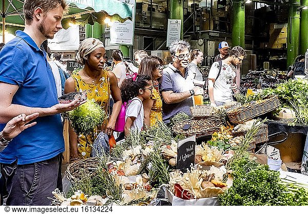 Menschen  die frisches Gemüse von einem Stand auf dem Borough Market in London  England  kaufen.