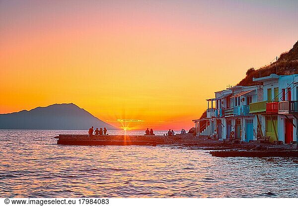 Menschen genießen den Sonnenuntergang im malerischen Dorf Klima über dem Ägäischen Meer auf der Insel Milos in Griechenland