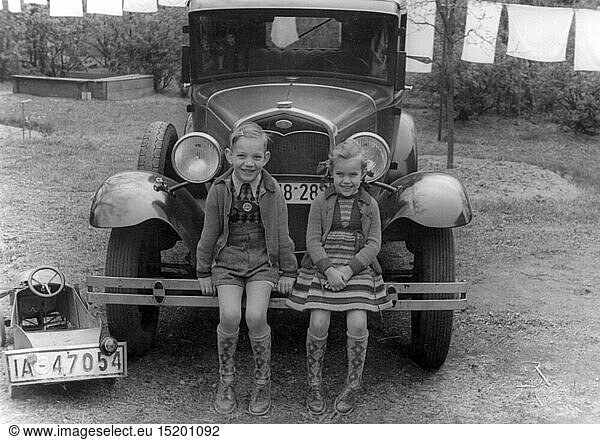 Menschen hist.  Kinder  Gruppen / Geschwister - gemischt  Junge und MÃ¤dchen auf der StoÃŸstange eines Auto sitzend  Berlin  1930er Jahre