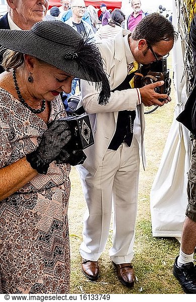 Menschen in historischen Kostümen machen Fotos mit altmodischen Kameras auf der Great Gatsby Fair  Bexhill on Sea  East Sussex  UK.
