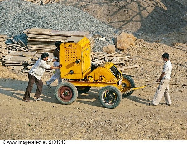 Menschen sind Motor  Engine  einem Trolley Beton am Bau eines Gebäudes aufzuheben tragen. Pune  Maharashtra  Indien.