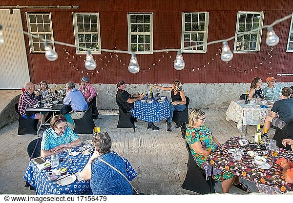 Menschen sitzen draußen an Tischen und genießen ein Abendessen vom Bauernhof  Conowingo  Maryland.