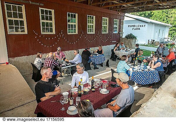 Menschen sitzen draußen an Tischen und genießen ein Abendessen vom Bauernhof  Conowingo  Maryland.