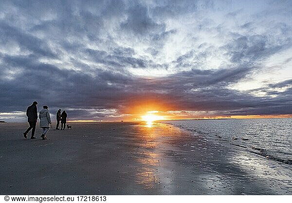 Menschen spazieren bei Sonnenuntergang am Strand  Langeoog  Ostfriesische Inseln  Niedersachsen  Deutschland  Europa