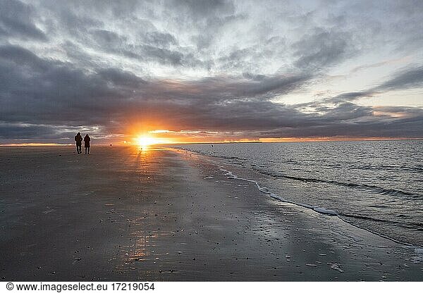Menschen spazieren bei Sonnenuntergang am Strand  Langeoog  Ostfriesische Inseln  Niedersachsen  Deutschland  Europa