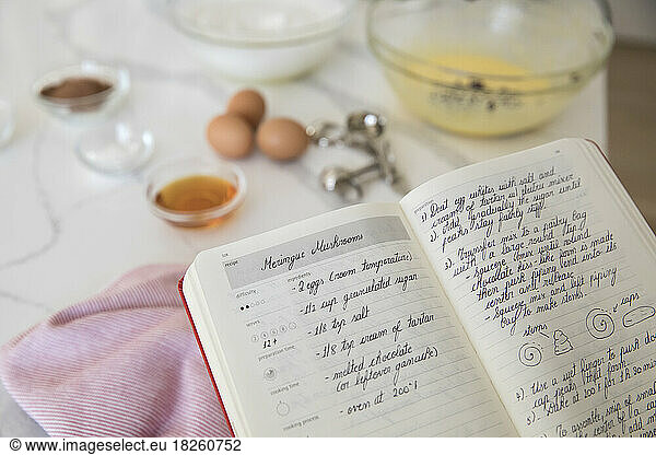 Merigue recipe in recipe book with baking ingredients