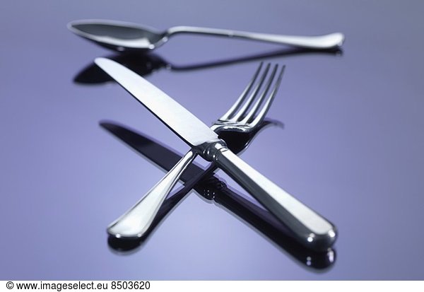 Messer und Gabel in Kreuzform mit Löffel