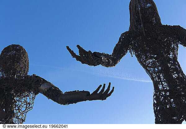 Metal sculpture of two people.