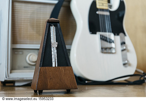 Metronome with electric guitar and old radio in the background