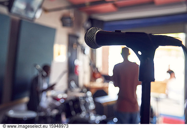 Microphone and musicians in garage recording studio