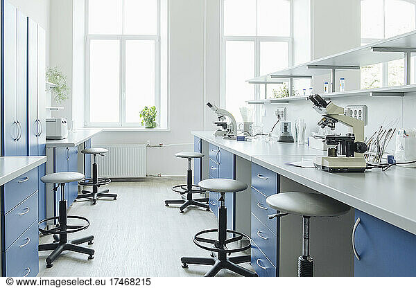 Microscopes at desk in bright empty laboratory