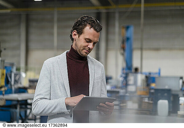 Mid adult businessman using digital tablet at industry