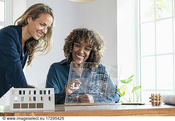 Mid adult businesswomen planning strategy on futuristic digital tablet at office