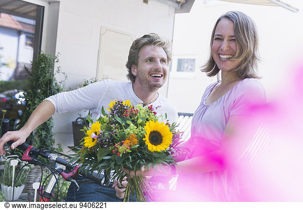 Mid adult couple in front of flower shop  smiling
