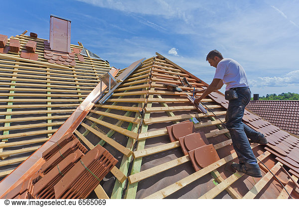 Mid adult man measuring roof tile