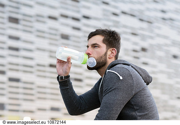 Mid adult man  outdoors  drinking from water bottle