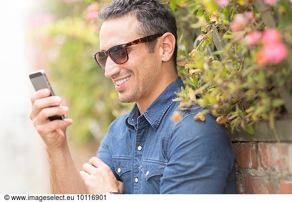 Mid adult man  outdoors  using mobile phone
