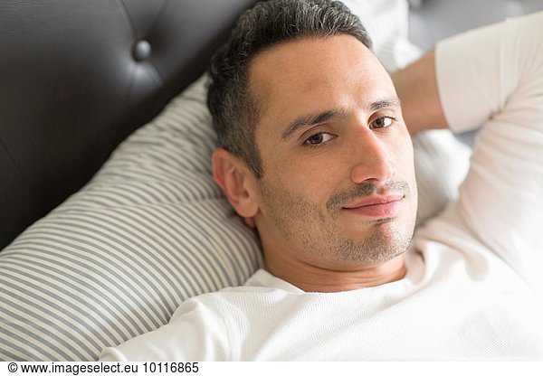 Mid adult man relaxing on bed