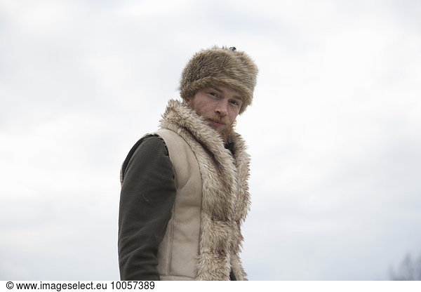 Mid adult man wearing furry waistcoat and trapper hat