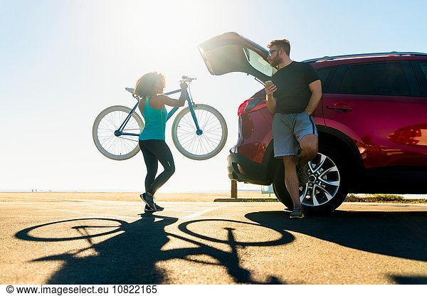 Mid adult woman putting bicycle into car boot