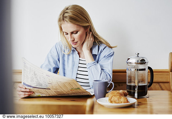 Mid adult woman reading newspaper