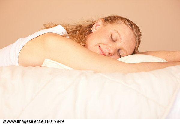 Mid adult woman sleeping on bed  smiling