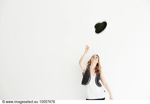 Mid adult woman throwing hat in the air  copy space