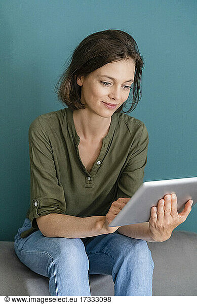 Mid adult woman using digital tablet at home