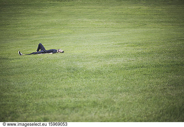 Mid distance view of man lying down over grassy land