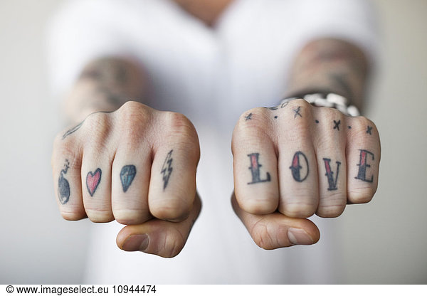 Mid section of a man showing love tattoos on his punch
