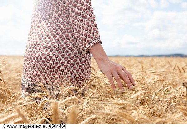 Mid section of woman in wheat field