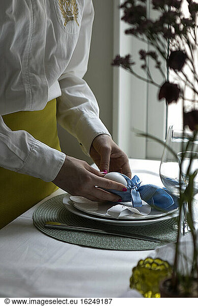 Mid section of woman preparing Easter place setting
