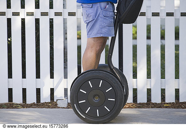 Mid section view of a man riding a segway