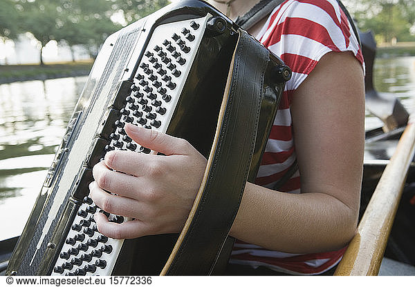 Mid section view of a woman playing accordion