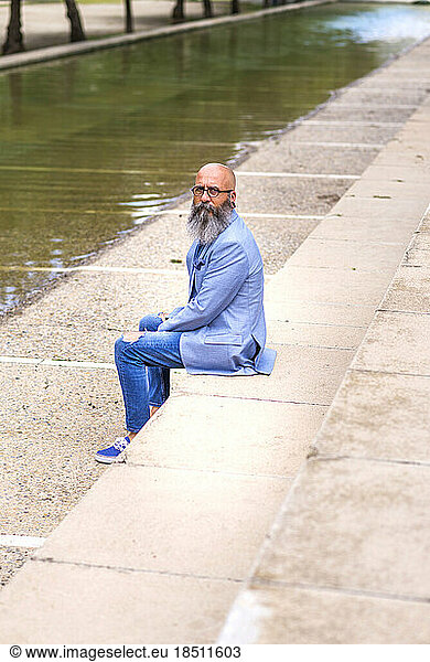 middle-aged  balding  bearded man sitting in a park relaxing
