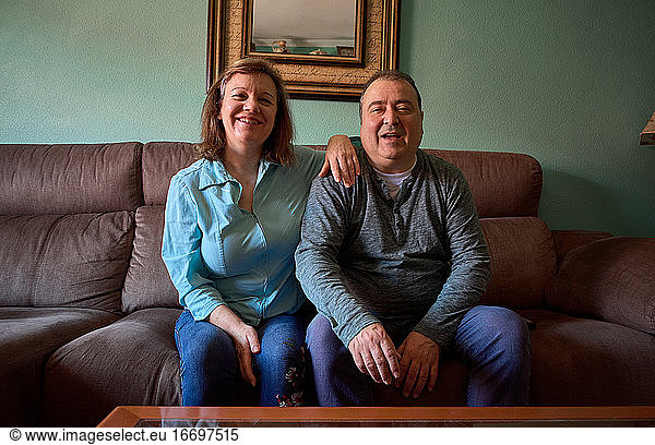 Middle-aged couple poses and smiles for a photo at home