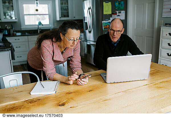 Middle aged couple with laptop together figuring their finances
