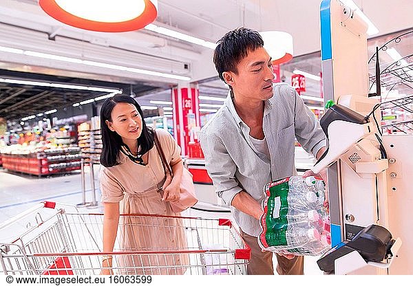 Middle-aged couples in the supermarket to buy mineral water