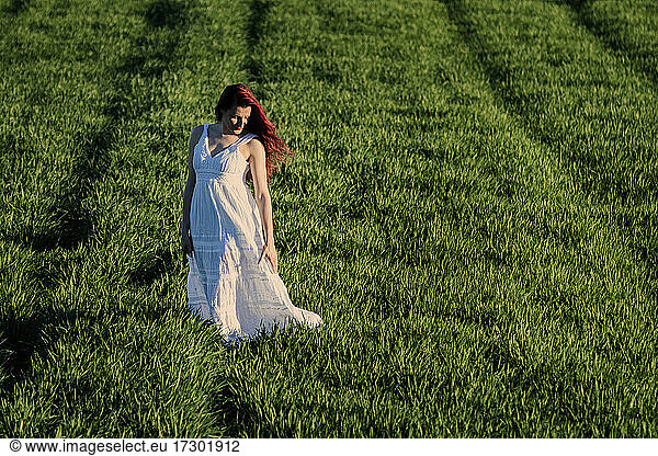 Middle aged woman in white dress in green grasses  healthy lifestyle