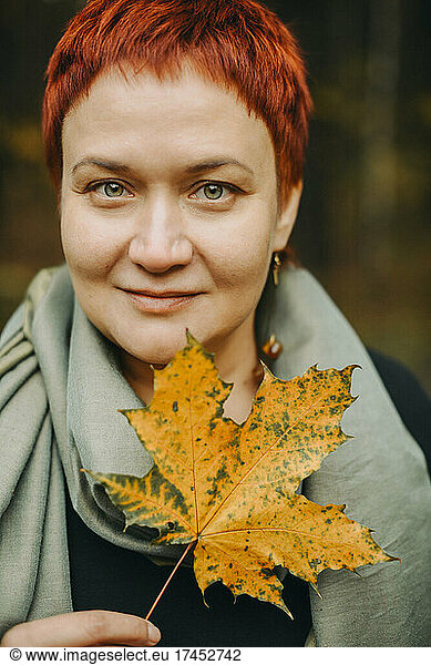 Middle-aged woman of 30-40 years old with autumn maple leaf